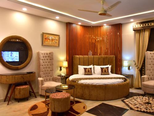 a bedroom with a bed and a mirror and a tv at Imperial Suites in Lahore