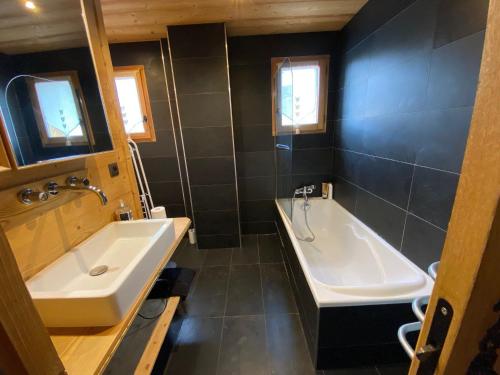 une salle de bain avec une baignoire et un lavabo et une baignoire dans l'établissement Appartement 3 chambres avec terrasse, balcon, terrain de boule, parking, wifi - FR-1-459-189, à La Clusaz