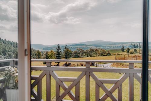 uma varanda com vista para um campo em Jeleni Jar Apartamenty em Duszniki Zdrój