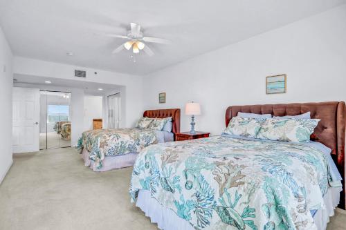 a bedroom with two beds and a ceiling fan at Oceanwalk Suite in New Smyrna Beach