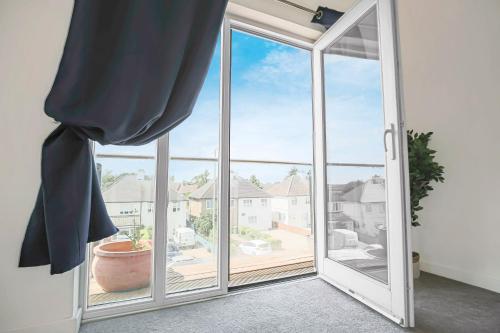 an open sliding glass door with a view of a yard at Duplex 2 Bedroom Apartment - Close to City Centre - Balcony, Free Parking, Fast Wifi & Smart TVs by Yoko Property in Milton Keynes