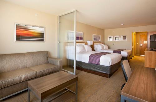ein Hotelzimmer mit 2 Betten und einem Sofa in der Unterkunft Holiday Inn Express Hotel & Suites Hot Springs, an IHG Hotel in Hot Springs