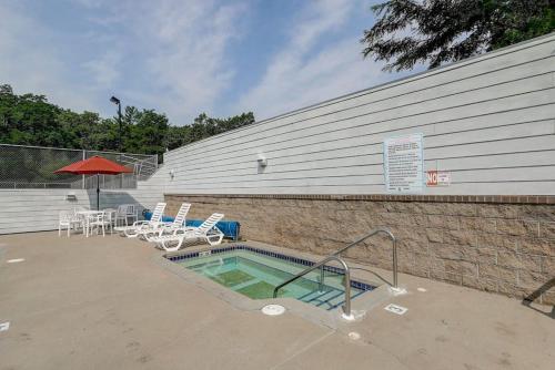 a swimming pool with chairs and a table and umbrella at Family Dreams Condo at Lighthouse Cove in Wisconsin Dells