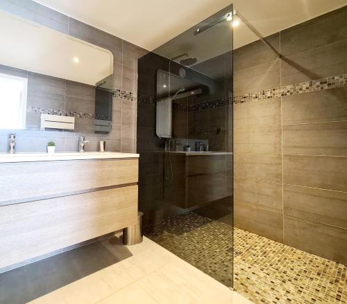 MAGNIFIQUE APPARTEMENT VUE MER - GRANDE TERRASSE ET PISCINE في باندول: حمام مع دش ومغسلة وحوض استحمام