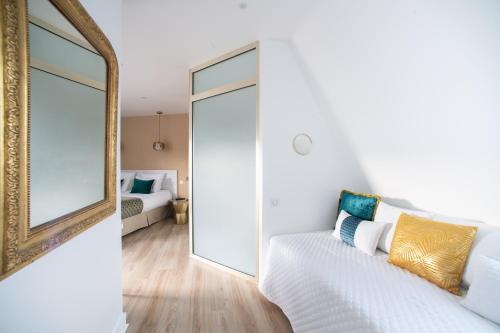 a room with a mirror and a bed in a room at Queens Boutique Hotel in Paris