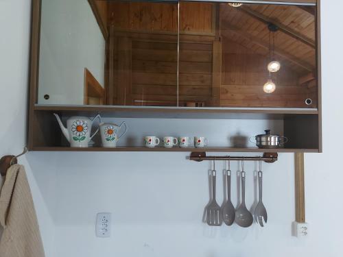 a kitchen with a shelf with utensils on it at Chalés Alpes do Vale- Gramado in Gramado