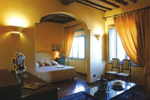 a bedroom with a bed and a room with a table at La Locanda Del Castello in San Giovanni dʼAsso