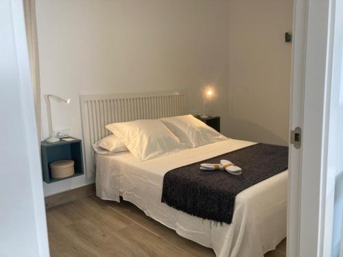 a bedroom with a bed with two shoes on it at Zona5 Apartamentos Turísticos in El Vendrell