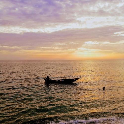 a boat in the middle of the ocean at sunset at Apartments and spa MIONA in Virpazar