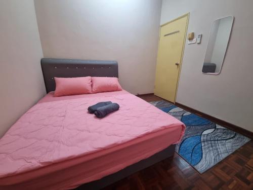 a small bedroom with a pink bed with a pink blanket at D’Lestari Homestay in Seri Kembangan