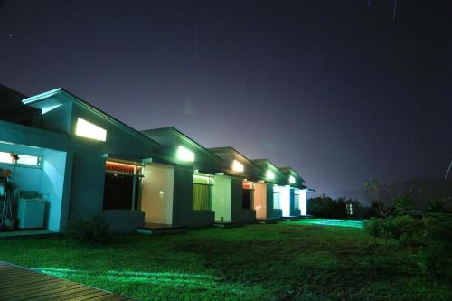 a row of houses lit up at night at Meet Canaan in Xikou
