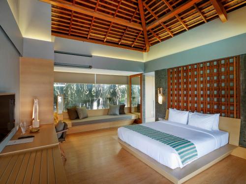 a bedroom with a large bed and a couch at The Santai by LifestyleRetreats in Canggu