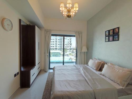 a bedroom with a large bed and a chandelier at 5*Amenities-2Br-15 min DxbApt,20min to Dubai Mall in Dubai