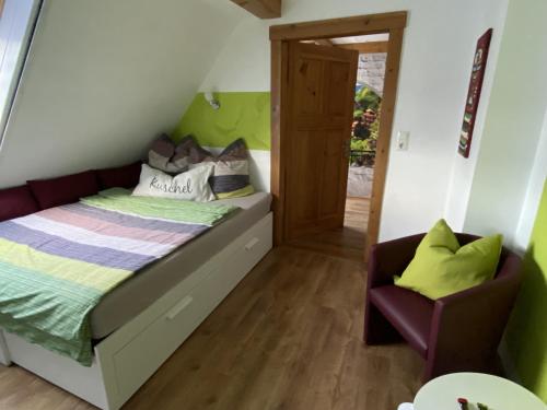 a small bedroom with a bed and a chair at Haus Steffine in Annahütte