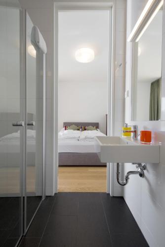 a bathroom with a sink and a mirror and a bed at Residence Bellevue - incl Summercard in Zell am See