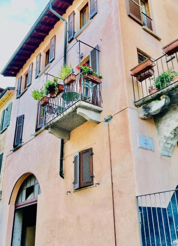 a building with windows and balconies with plants on them at Via Scale Apartments, Lake Como, Brienno in Brienno