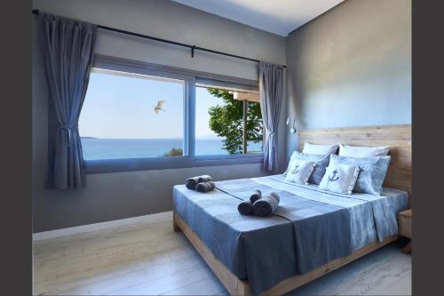 a bedroom with a bed with a large window at DEVELIKIA PRIVATE VILLA 2 - Ierissos in Ierissos