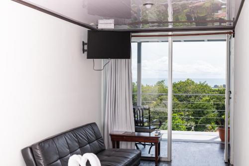 a living room filled with furniture and a window at El Faro Beach Hotel in Manuel Antonio