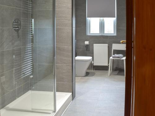 a bathroom with a glass shower and a toilet at The Lodge in Linlithgow