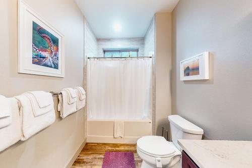 a white bathroom with a toilet and a shower at Siuslaw Tides 1 in Florence