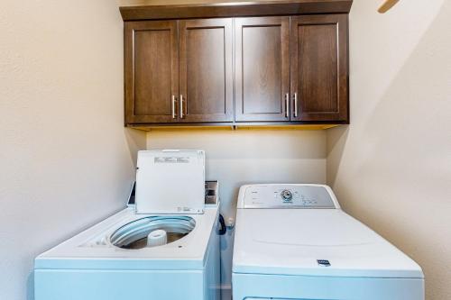a washer and dryer in a small kitchen with a cabinet at Siuslaw Tides 2 in Florence