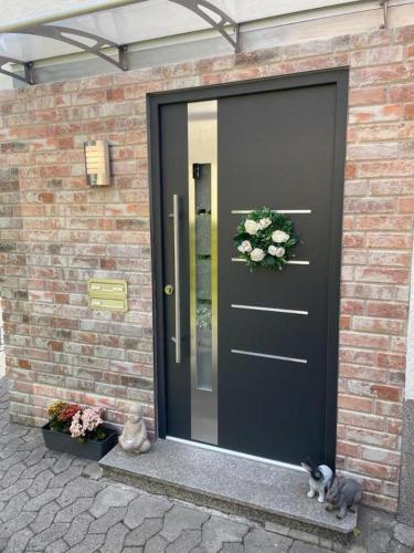 a black door with a cat sitting in front of it at Ferienwohnung M&M in Herford