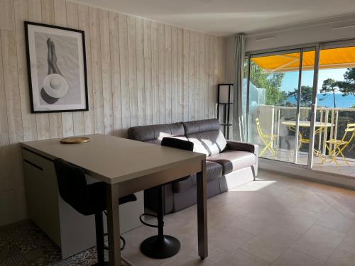 un salon avec un canapé et une table dans l'établissement Côté plage Nauzan Vue mer, à Vaux-sur-Mer