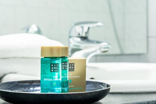 a bottle of hand soap in a bathroom sink at Hotel Edenpark in Brunssum