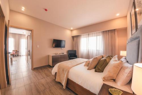 a hotel room with a bed and a television at Fully Serviced Apartment at Regatta Living - 3A in Santo Domingo