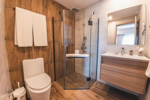 a bathroom with a shower and a toilet and a sink at Fully Serviced Apartment at Regatta Living - 3A in Santo Domingo