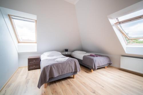 two beds in a room with two windows at Dom na Mazurach LUNA HAUS in Ełk