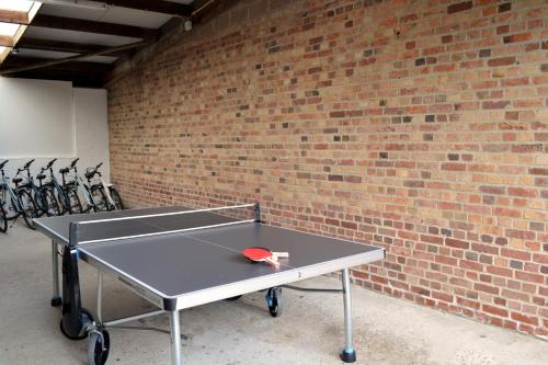 a ping pong table in front of a brick wall at Potter's Place by Ardenne Places in Theux