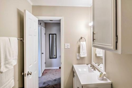 ein weißes Badezimmer mit einem Waschbecken und einem Spiegel in der Unterkunft Cozy Ruston Townhome Less Than 1 Mi to Louisiana Tech in Ruston
