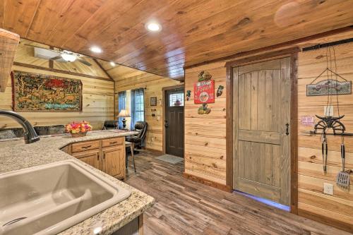 a kitchen with wooden walls and a sink and a door at Cozy Tree Top Cabin about 3 Mi to Lake Hamilton in Hot Springs