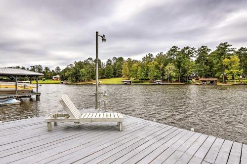 a white chair sitting on a dock next to the water at Eatonton Getaway on Lake Sinclair with Dock! in Resseaus Crossroads