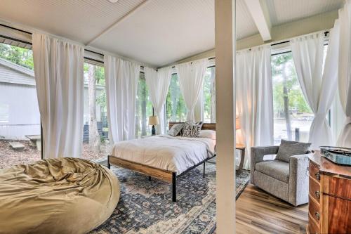 een slaapkamer met een bed, een stoel en ramen bij Eatonton Getaway on Lake Sinclair with Dock! in Resseaus Crossroads