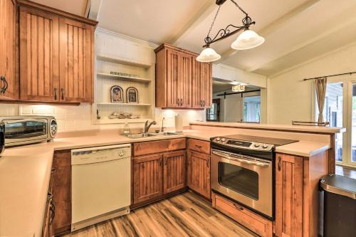 a kitchen with wooden cabinets and a stove top oven at Eatonton Getaway on Lake Sinclair with Dock! in Resseaus Crossroads
