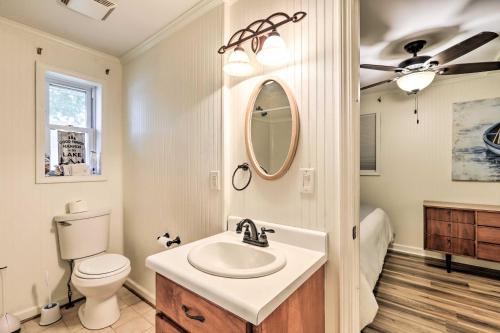 a bathroom with a sink and a toilet and a mirror at Eatonton Getaway on Lake Sinclair with Dock! in Resseaus Crossroads