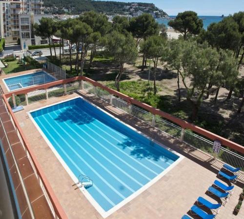 uma vista superior de uma piscina com cadeiras em Primera línea y vistas al mar con piscina em L'Estartit