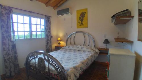 ein Schlafzimmer mit einem Bett in einem Zimmer mit einem Fenster in der Unterkunft Los Agapantos in Concordia