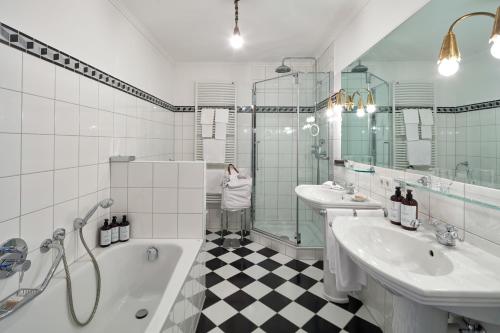 a bathroom with two sinks and a tub and a shower at Kristiania Lech in Lech am Arlberg