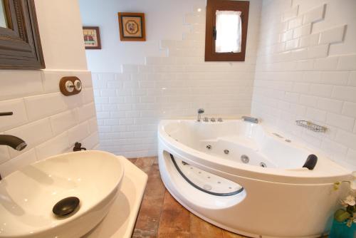 a white bathroom with a tub and a sink at Cuencaloft La Casa Del Pintor in Cuenca