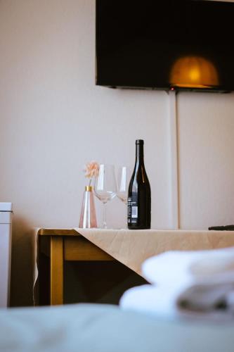 una bottiglia di vino e due bicchieri su un tavolo di Hotel Dalmacija a Mayen