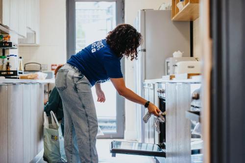 a woman is reaching into an open refrigerator at Snoozles Galway City Centre in Galway