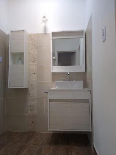 a bathroom with a white sink and a mirror at Cabaña Los Pajaritos in Villa Rumipal