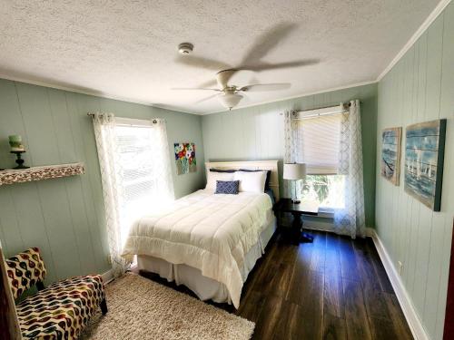 a bedroom with a bed and a ceiling fan at Beautiful Lakefront Cottage with Boat Dock in Lucas
