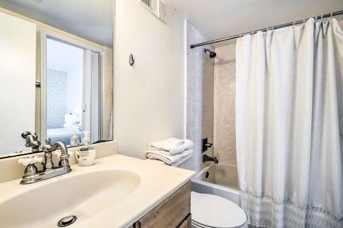 y baño blanco con lavabo y ducha. en Coastal Condo with Pool Access - Steps to Beach en Carolina Beach