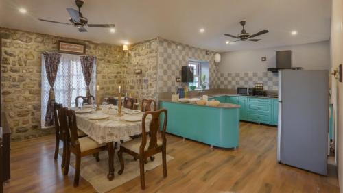 Un comedor con una mesa y una cocina. en Jim & Holmes Resort & Luxury Residences in Jim Corbett National Park, en Rāmnagar