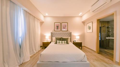 a bedroom with a large bed and two lamps at Fully Serviced Apartment at Regatta Living - 9F in Santo Domingo