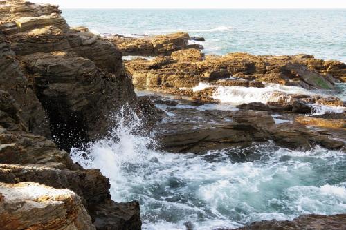 una ola chocando en las rocas cerca del océano en Logis Hôtel Restaurant Le Calluna en Préfailles